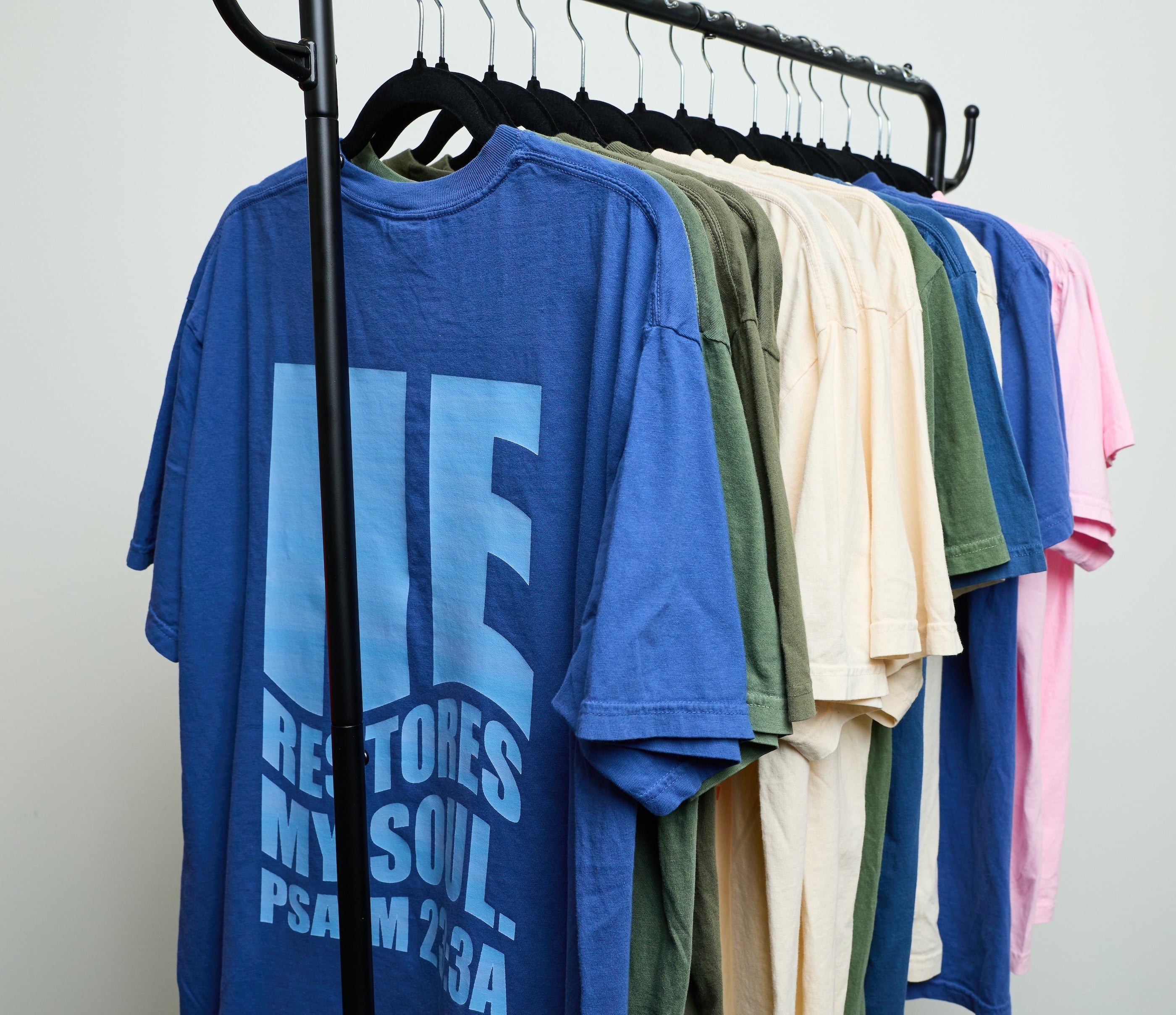 Psalm 23 T-Shirt Collection on a clothing rack.